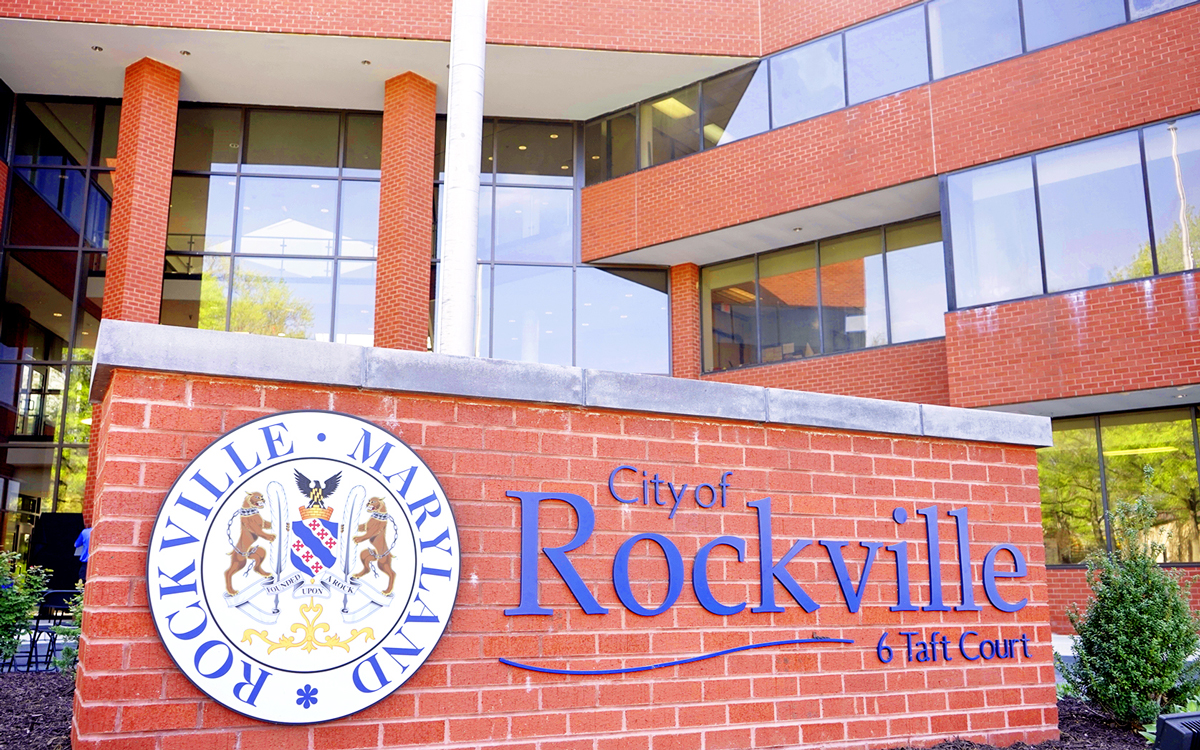 Exterior view of the City of Rockville, Maryland municipal building with a large sign displaying the city name and emblem in front.